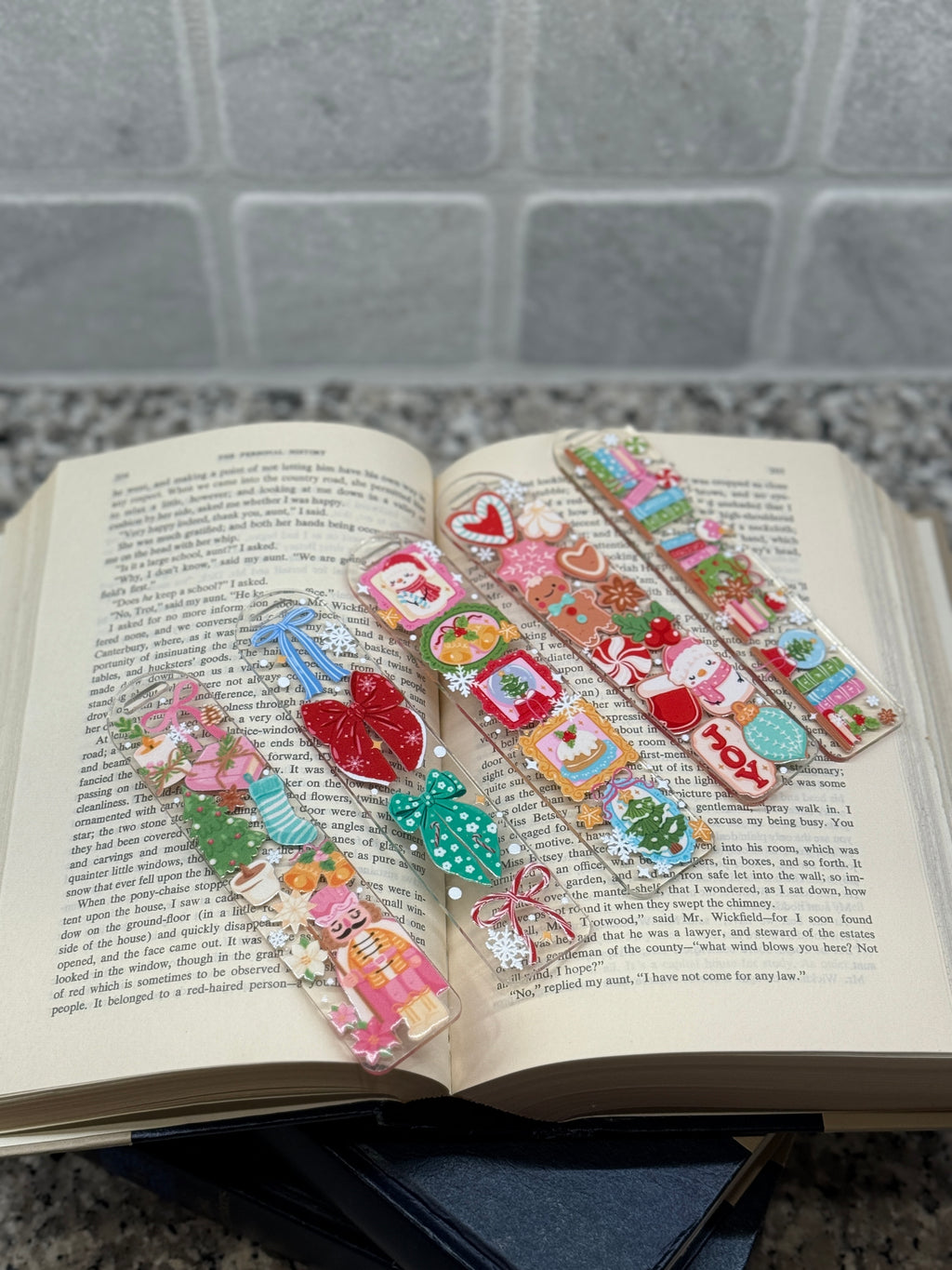 Colorful decorative bookmarks on an open book with a gray tiled background