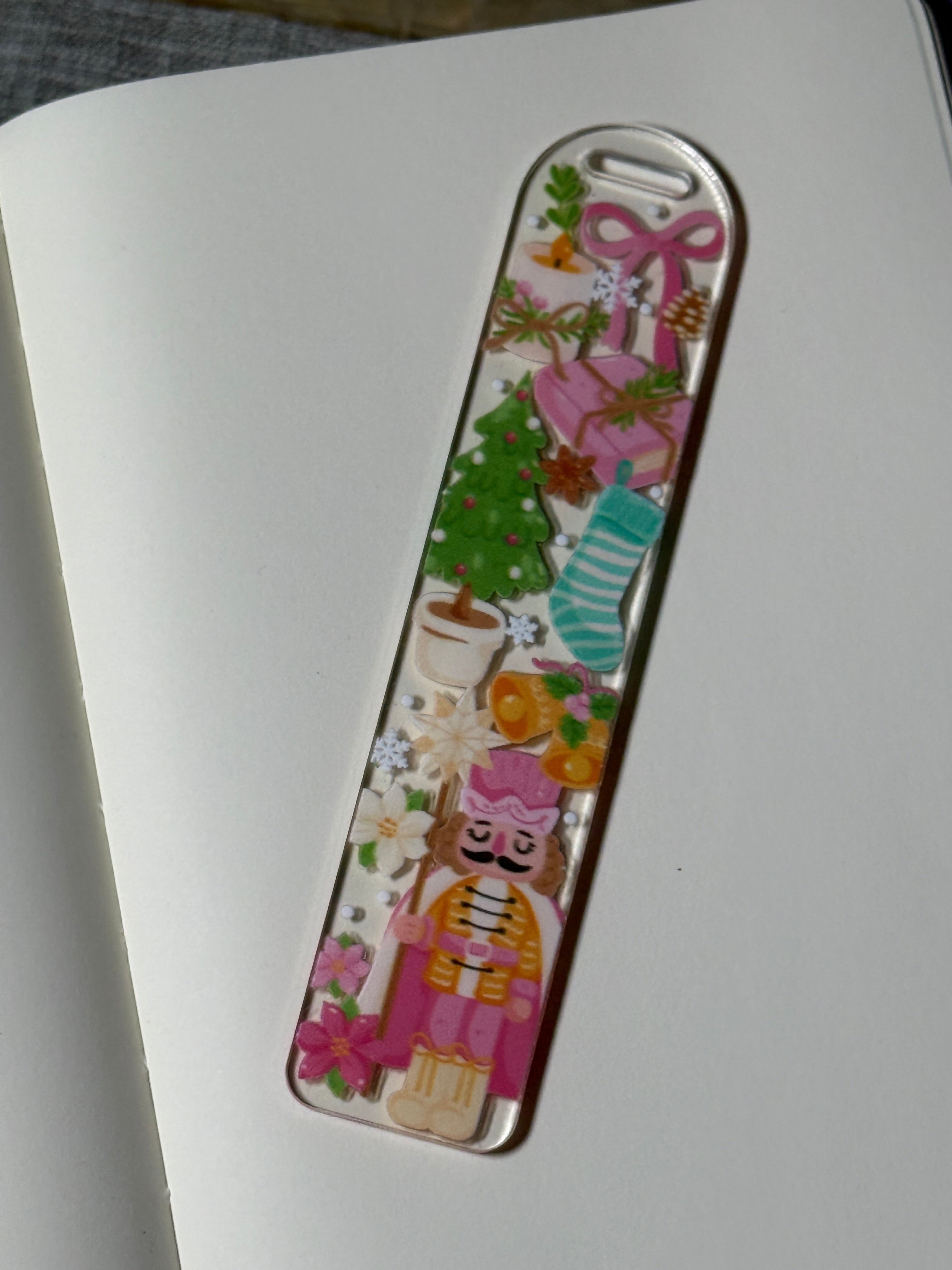 Sugar Plum Nutcracker Christmas bookmark on an open notebook with pink presents, Christmas tree, and nutcracker art.